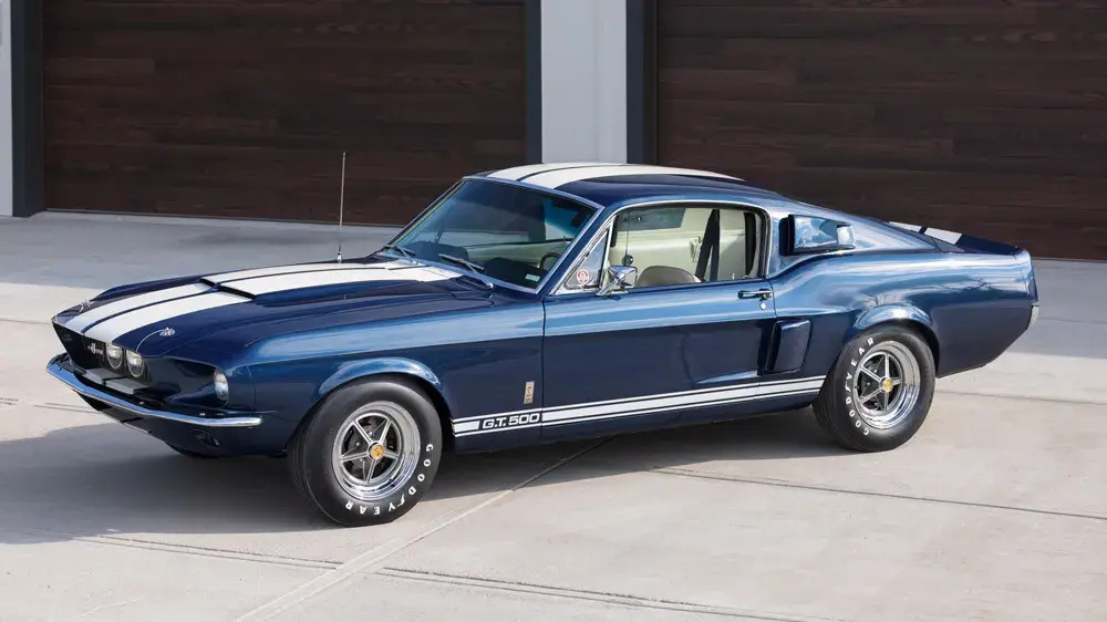 image of a blue 1967 Shelby GT500 with a white racing stripe and Goodyear tires
